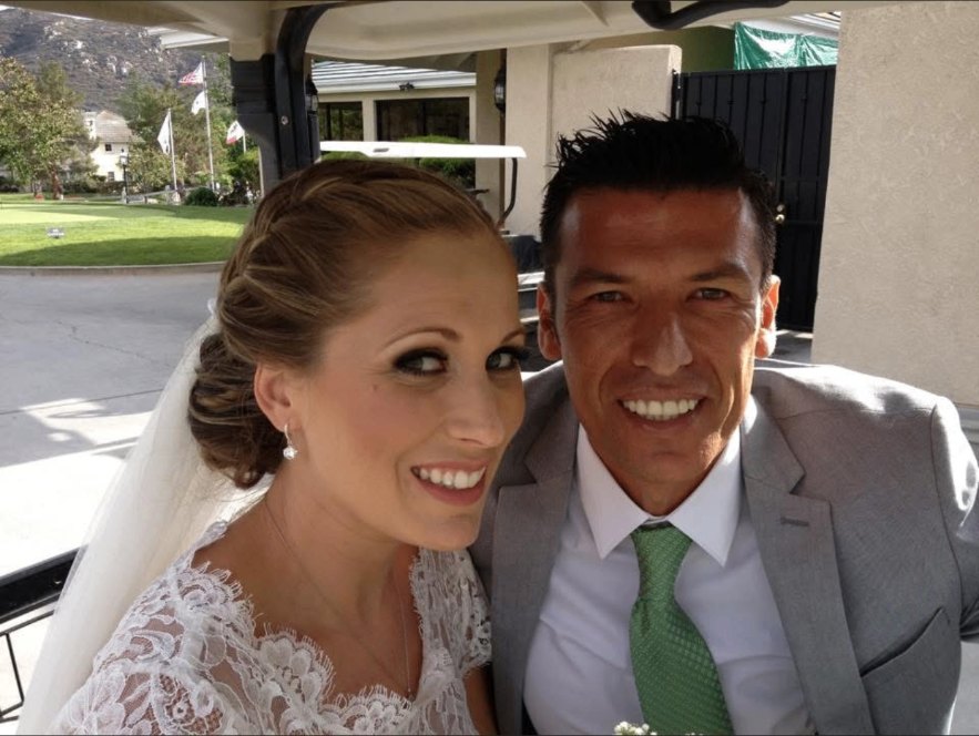 Newlyweds smiling together in a golf cart after their ceremony