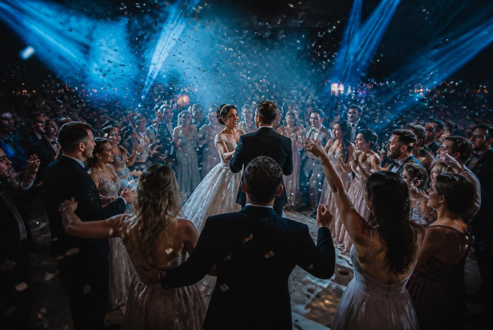 Bride and groom dancing as confetti falls over the dance floor