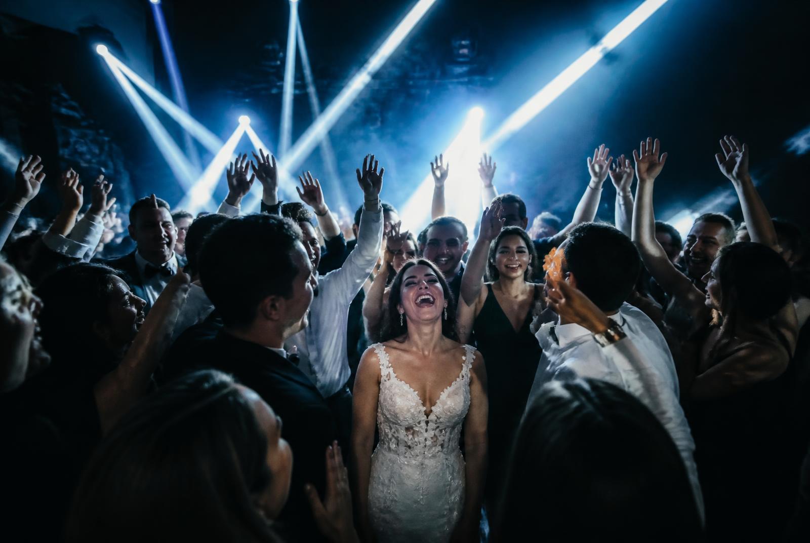 Wedding guests with hands up on a packed dance floor